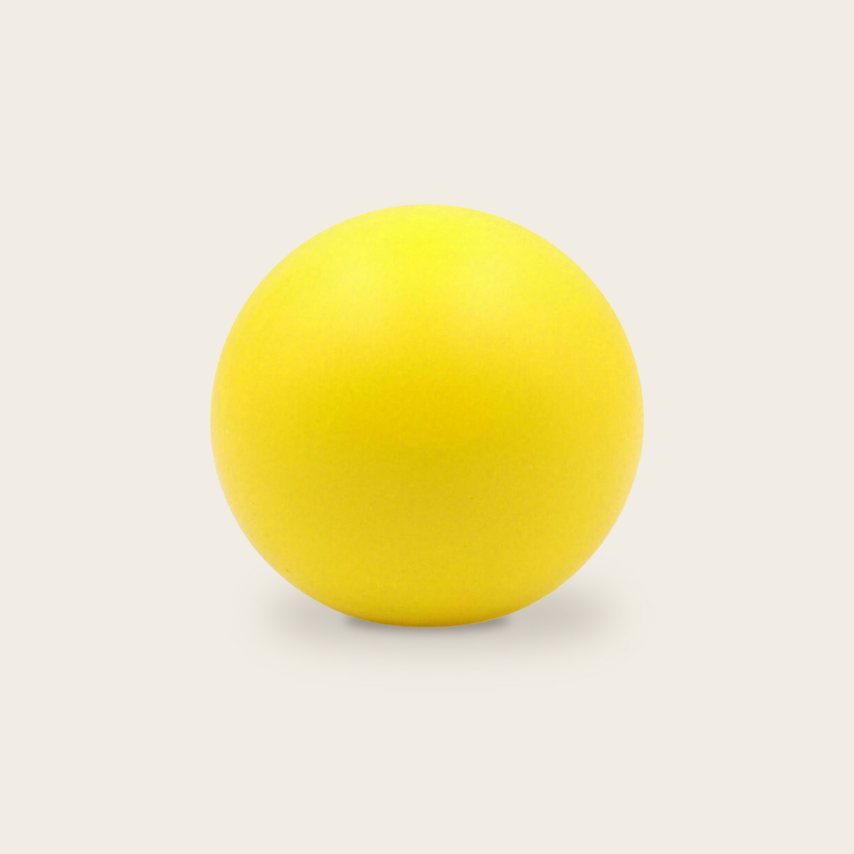 Soft grip strength ball in yellow on a cream background