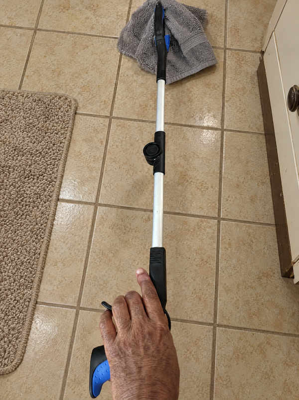Looking down the grabber to pick a towel up off the bathroom tiles