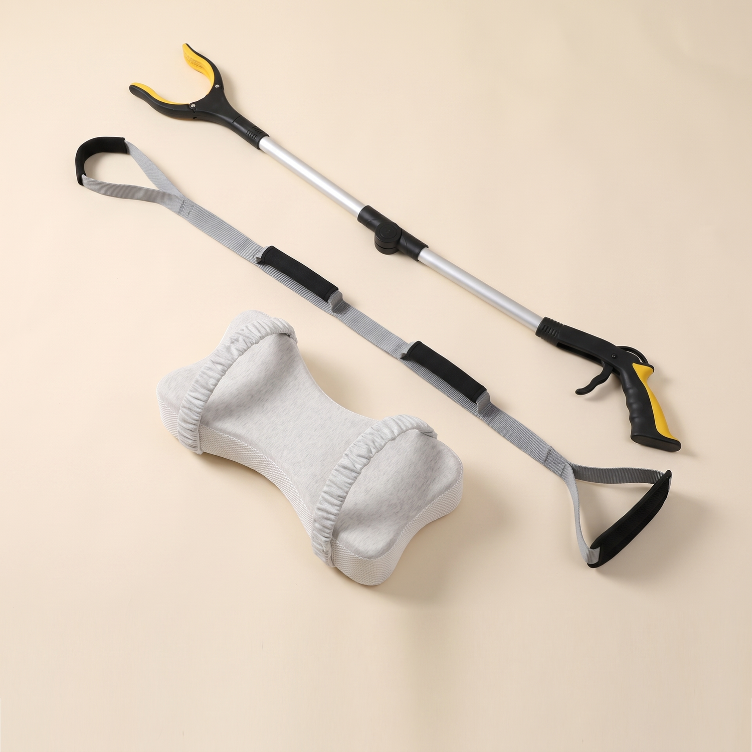 Long reach grabber, leg lifter and bone shaped knee pillow on a cream background