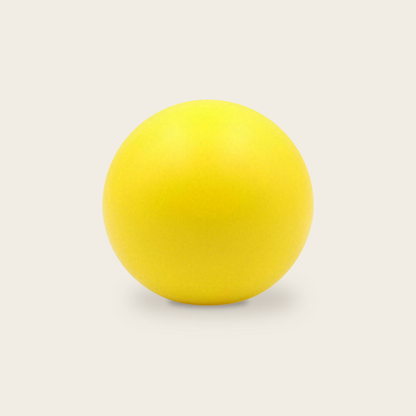 Soft grip strength ball in yellow on a cream background