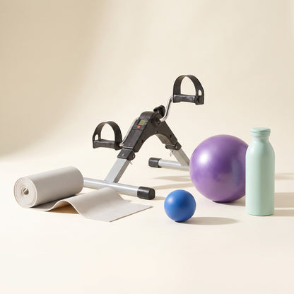 The Home Exercise Essentials Kit seen from floor level, showing the height of the pedal exerciser and the true size of the mini exercise ball and water bottle.