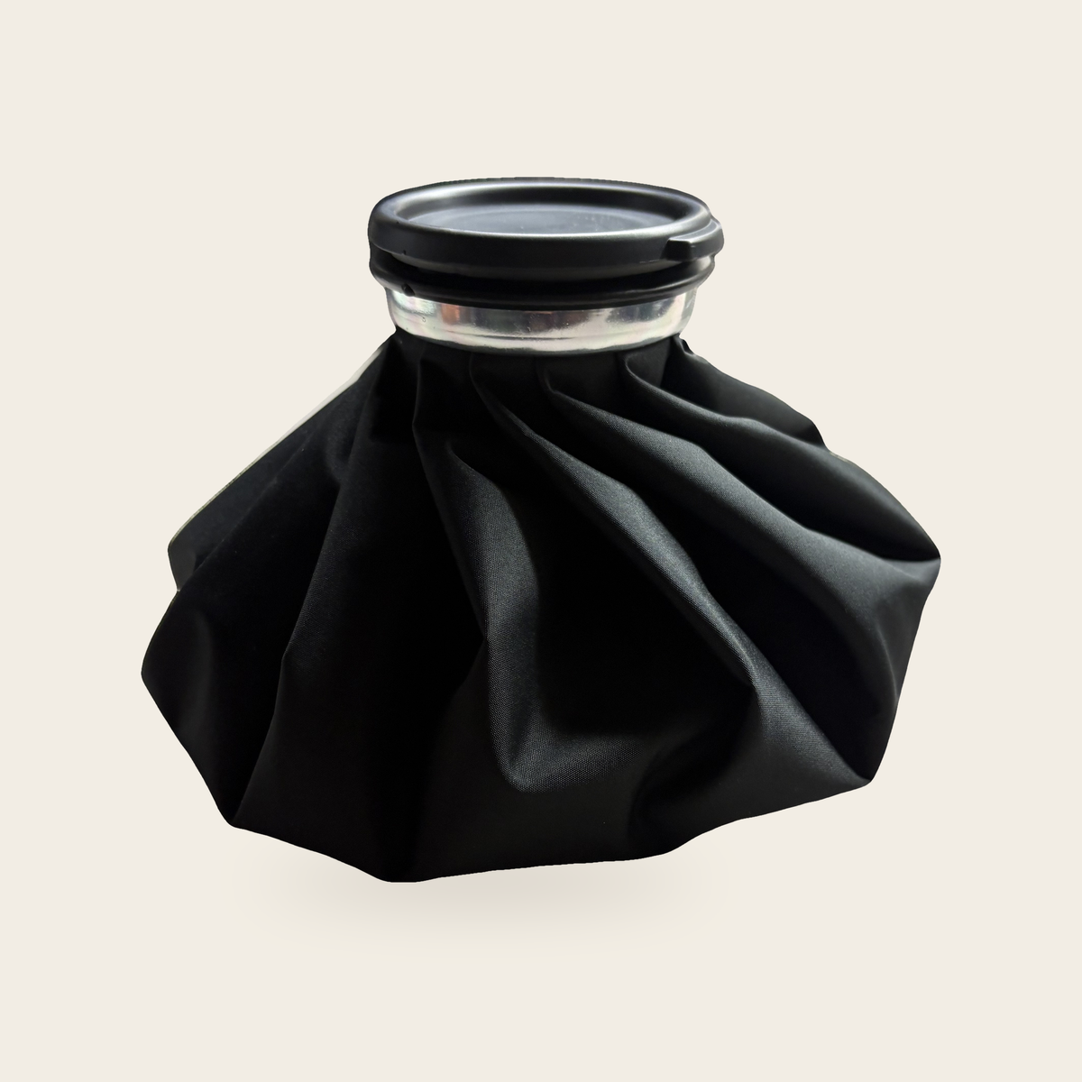 Reusable 9 inch black fabric ice bag with a black screw cap, on a cream background