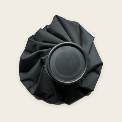 The ice bag seen from above, showing the wide black screw cap and pleated fabric