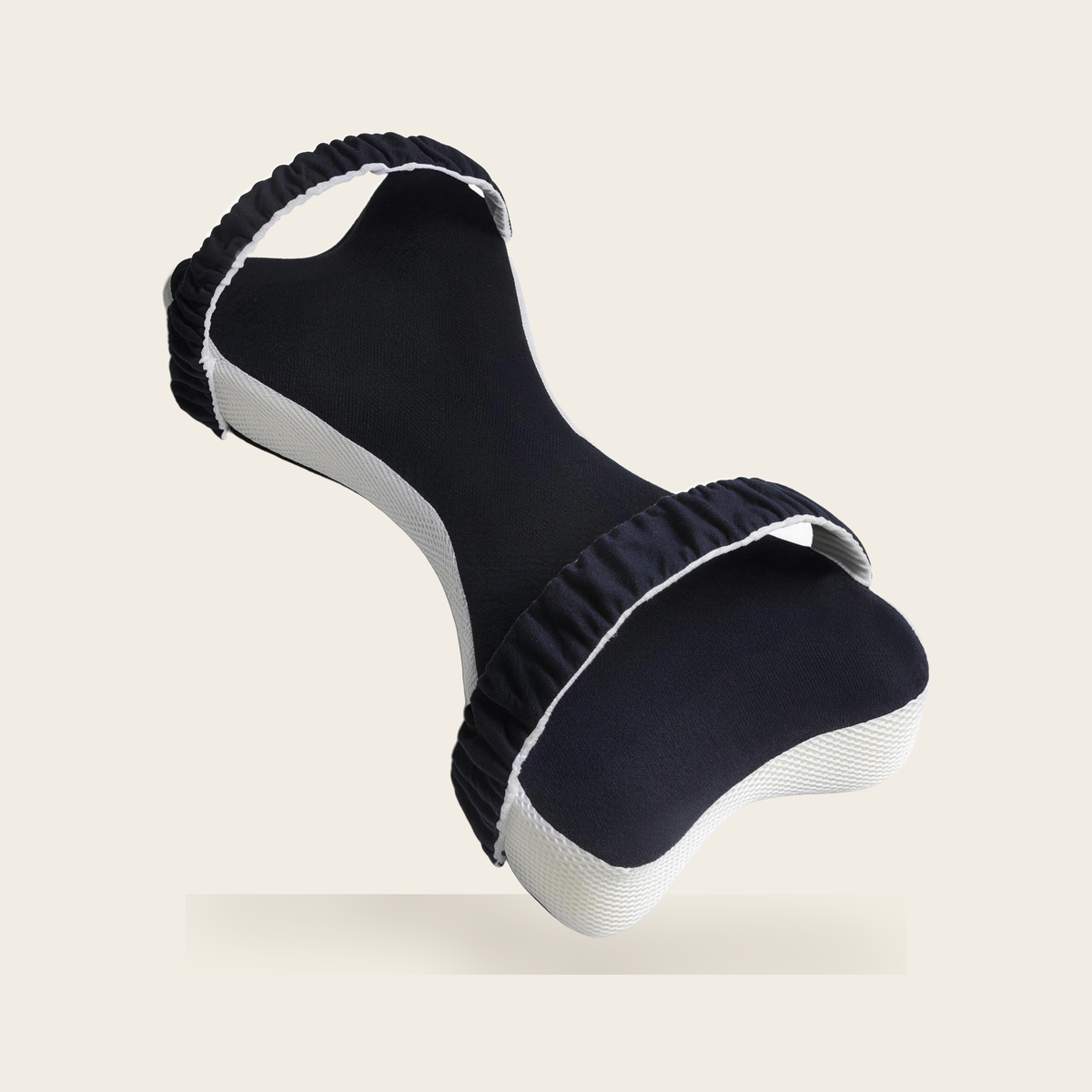 Bone shaped long knee pillow in navy blue with two ruched straps on a cream background
