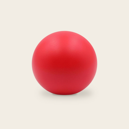 Soft grip strength ball in red on a cream background