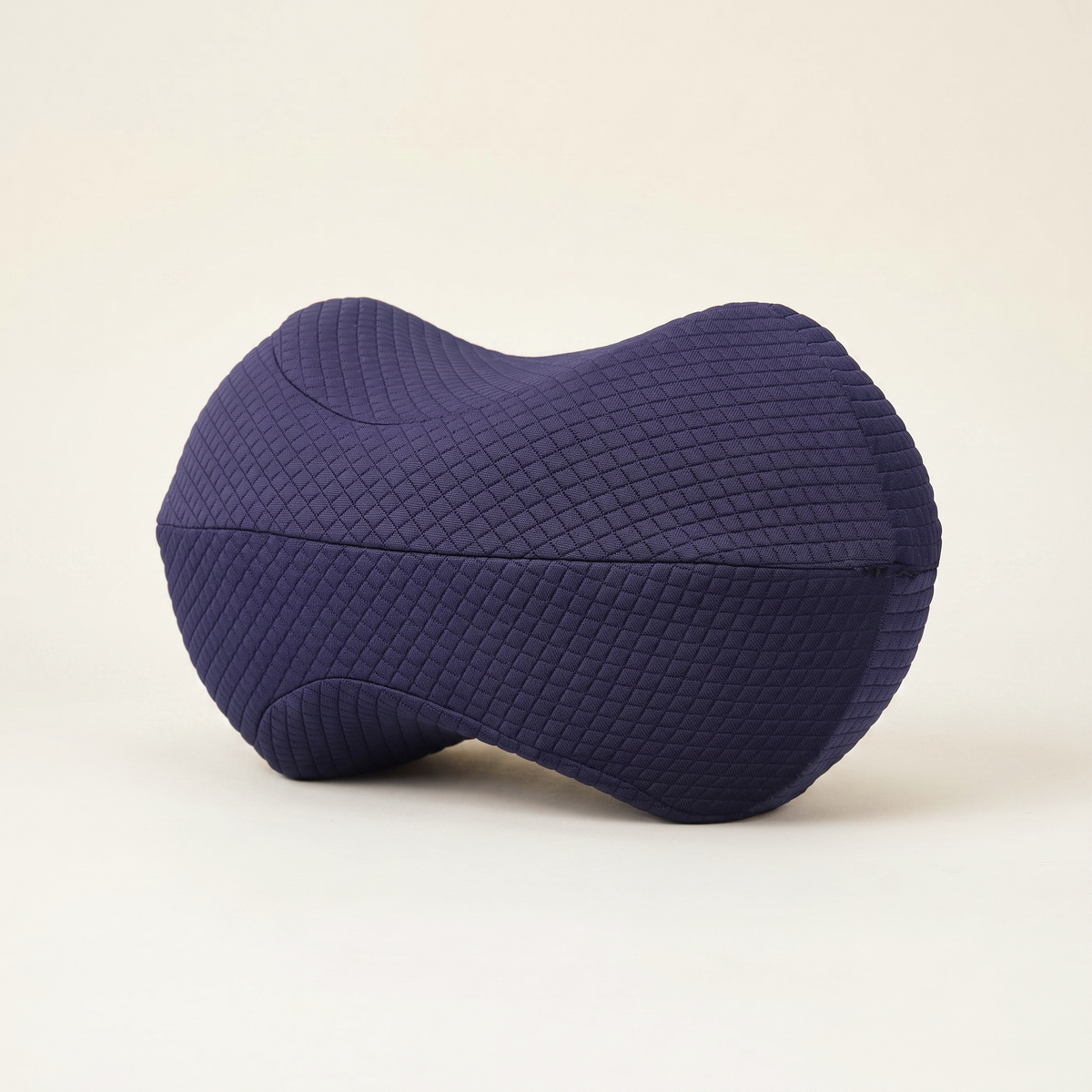 Navy Bean Knee Pillow with a quilted cover on a cream background