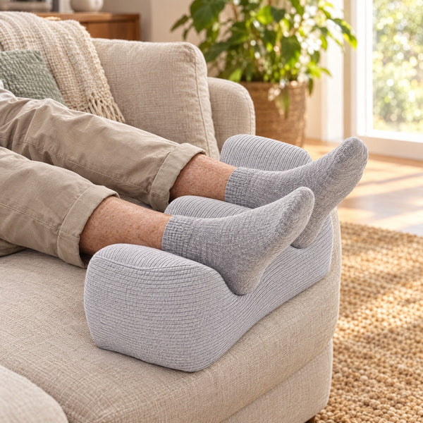 Ankles resting in the two grooves of the Comfort Leg Pillow on a couch