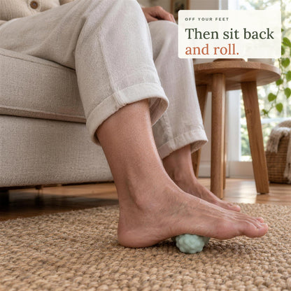 Sitting back in an armchair with a bare foot on the peanut massage ball