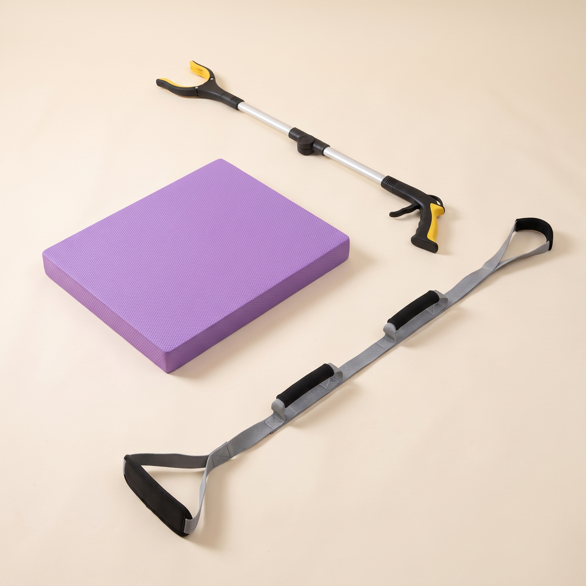 Balance & Independence Kit on a cream background: purple balance pad, foldable long reach grabber and triple grip leg lifter strap.