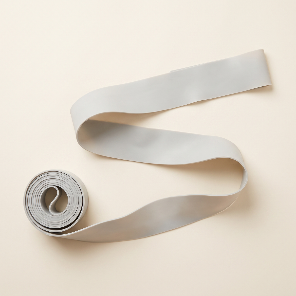 The kit's Long Resistance Band partly unrolled from its supplied roll, showing its two metre length.