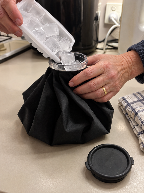 Filling the ice bag with ice cubes through the wide neck, cap set aside